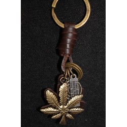 Porte clefs en cuir et métal avec plusieurs breloques, feuille, anneaux.